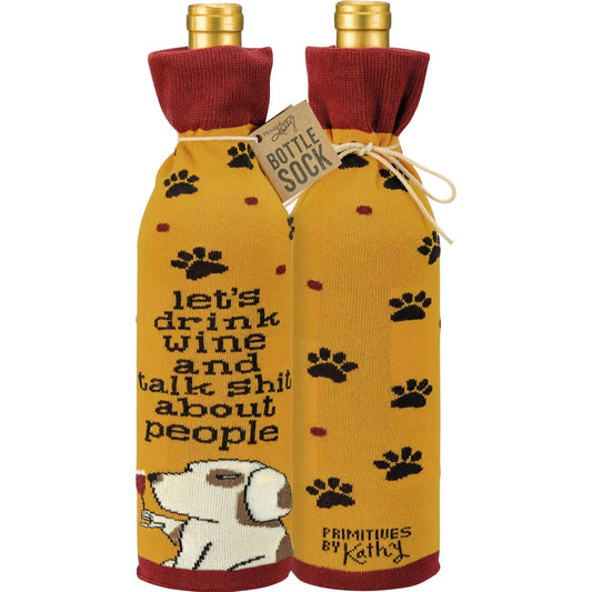 A funny knit bottle sock featuring playful paw prints and a dog sipping wine with the saying “Let’s Drink Wine And Talk Shit About People.”