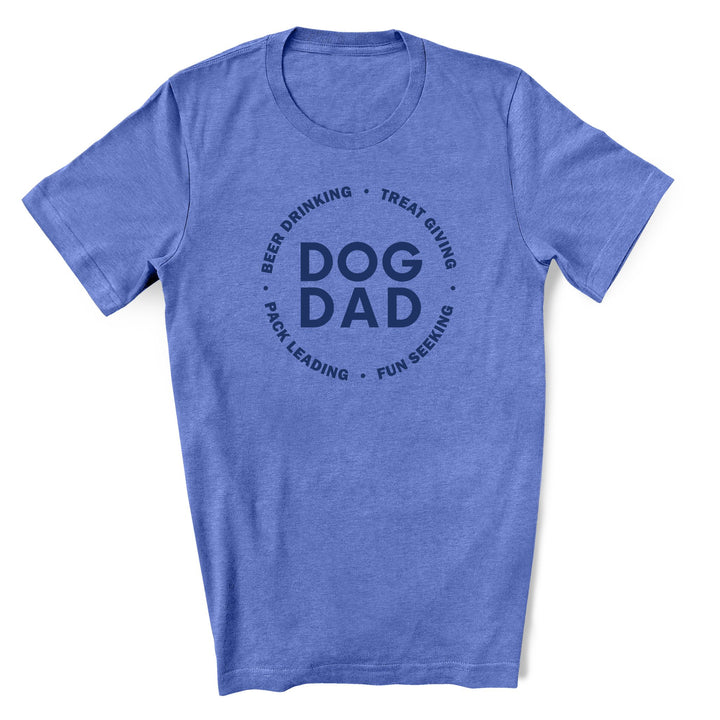 A funny dog dad shirt that is blue with Dog Dad in blue text in the middle and Beer drinking, treat giving, pack leading, fun seeking in blue text featured in a circle around it.