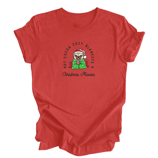 A cozy Christmas-themed shirt in heather red featuring a pug enjoying a hot beverage and snuggling under a blanket.