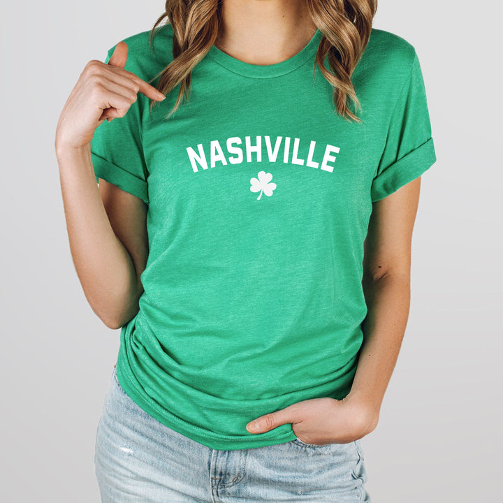 A heather kelly green Nashville St. Patrick’s Day shirt with shamrock graphic on a female