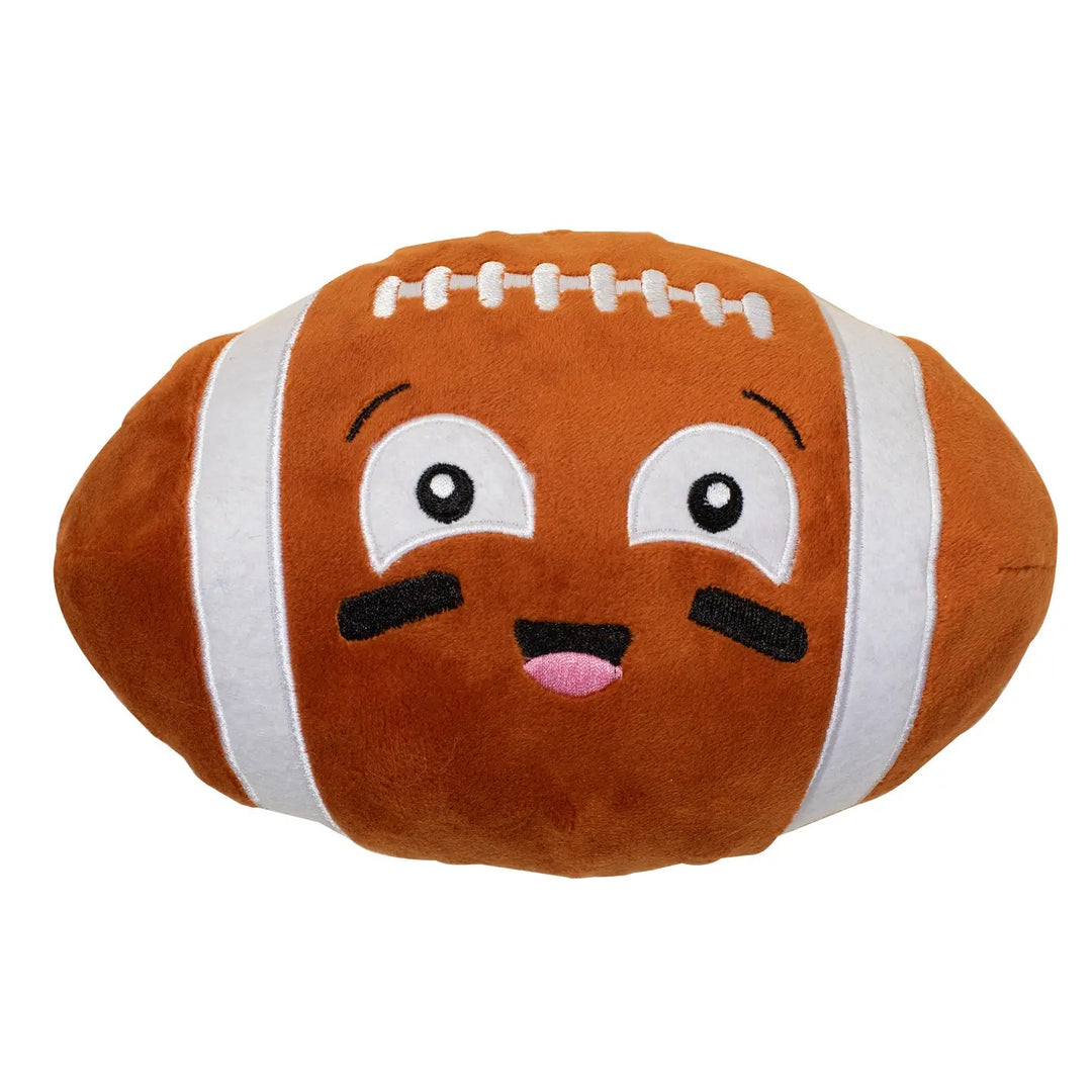 A brown plush football pillow with a cute cartoon face, featuring embroidered white stripes, white laces, and a smiling expression on a plain white background.