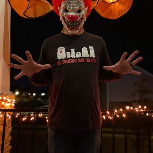 Man with a scary clown face wearing a long-sleeve black t-shirt that has ghostly canines and says did someone say treat.