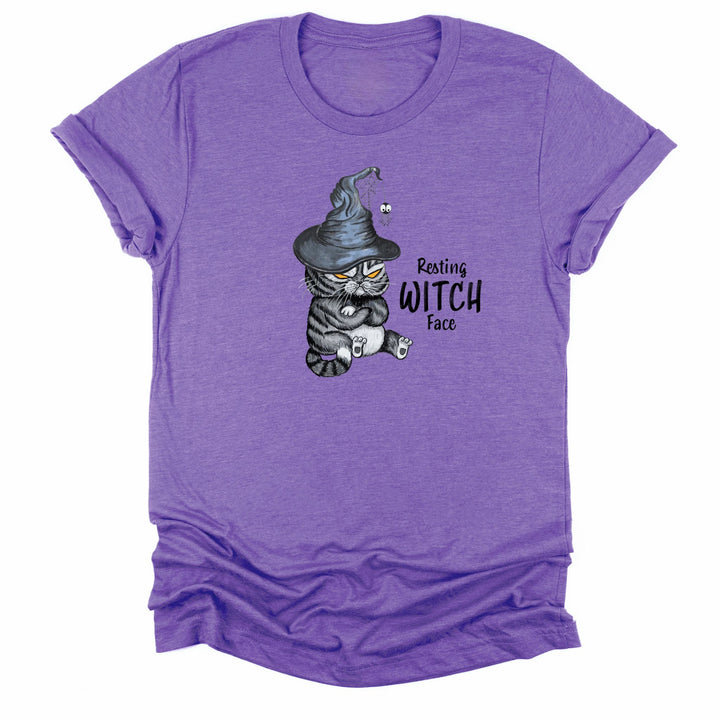 A purple heather short-sleeve t-shirt with a cartoon graphic of a grumpy witch cat wearing a pointed hat, accompanied by the text &