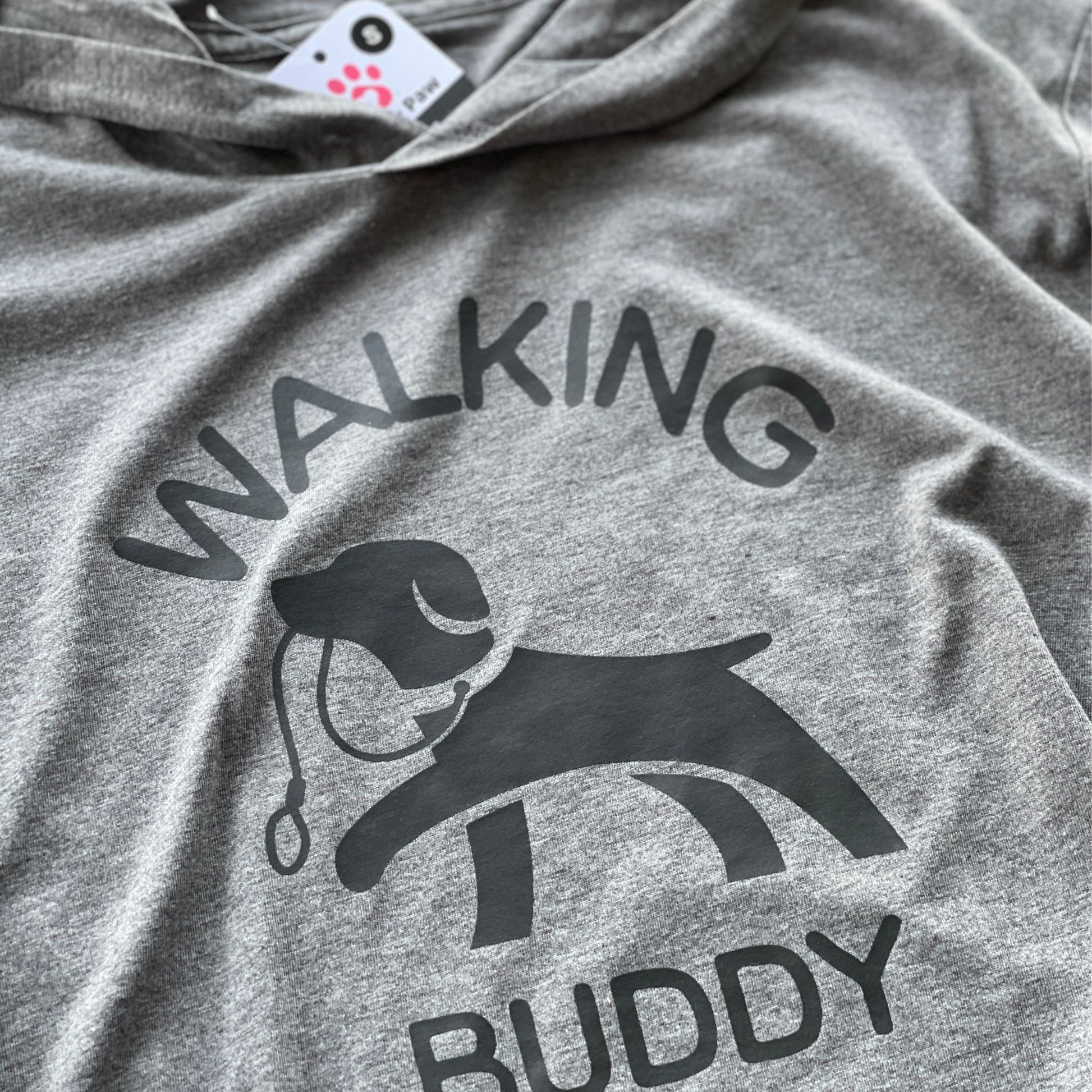 Hoodie for dog owner that says 'walking buddy' in text and in the middle a dog holding a leash in its mouth