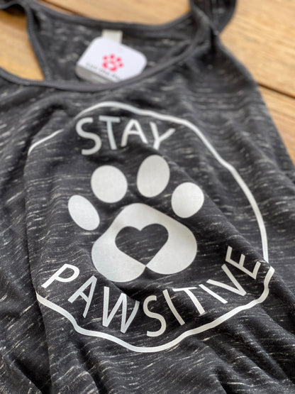 Flat lay closed up of Women’s Stay Pawsitive tank top in black marble. It features the Luv the Paw Logo paw print with heart and Stay Pawsitive Text - lightweight racerback style perfect for yoga and pet lovers.